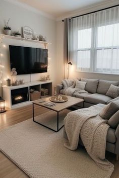 a living room filled with furniture and a flat screen tv mounted on the wall above a fire place