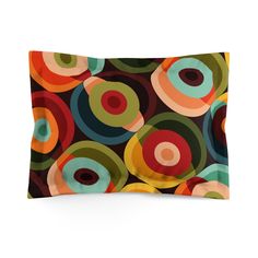 a pillow case with colorful circles on the front and back cover in black, green, orange