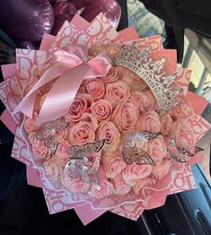 a bouquet of pink roses and butterflies on display in a car door window sill