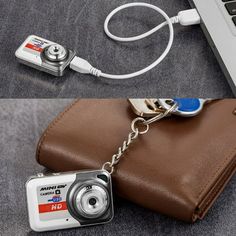 a camera keychain attached to a brown purse with a laptop in the background