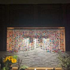 a kitchen counter topped with lots of pots and pans next to a window covered in colorful beads