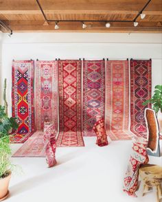 a room filled with lots of colorful rugs and plants on top of it's walls