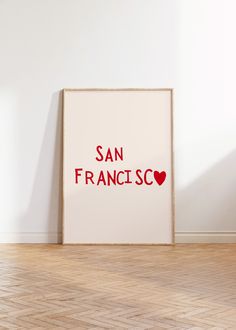 a white framed poster with the words san francisco printed on it in red and black