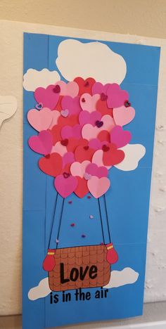 a card with hearts floating in a hot air balloon