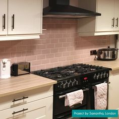 a stove top oven sitting inside of a kitchen next to white cabinets and counter tops