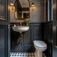 a bathroom with black and white checkered wallpaper, gold fixtures and a pedestal sink