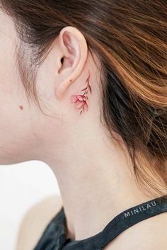 a woman wearing a black top with pink flowers on her left side behind her ear