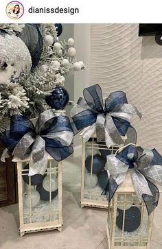 two small white lanterns with blue and silver bows