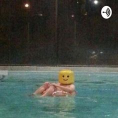 a person floating in a pool with a smiley face on their head