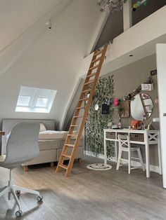 an attic bedroom with a loft bed, desk and ladder leading to the top floor