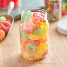 a jar filled with gummy bears sitting on top of a wooden table