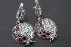 These beautiful pomegranate-shaped earrings are made in the national Armenian style with Armenian patterns and ornaments. The earrings are made of high quality silver and red, almost burgundy zircon stones. The pomegranate fruit is found in the mythologies and cultures of many countries. For Armenians and Jews, it is a symbol of family, children and prosperity. For the Greeks - a symbol of wealth. But in the end it all comes down to the fact that the pomegranate fruit is certainly a symbol of ab Elegant Cranberry Jewelry For Gift, Fine Jewelry Silver Garnet Jewelry, Handmade Fine Jewelry With Garnet, Traditional Garnet Jewelry As Gift, Garnet Dangle Jewelry For Weddings, Exquisite Handmade Silver Earrings, Traditional Garnet Jewelry For Gifts, Wedding Garnet Dangle Jewelry, Wedding Dangle Garnet Jewelry