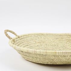 a woven basket with handles on a white background