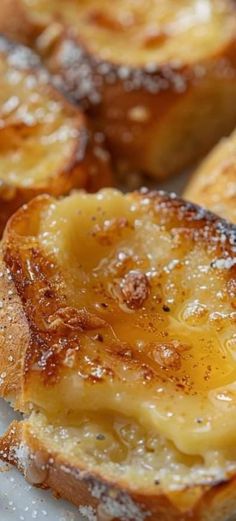 french toast topped with pineapple sauce and powdered sugar, on a white plate