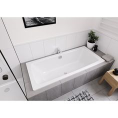 a white bath tub sitting on top of a tiled floor next to a wooden table