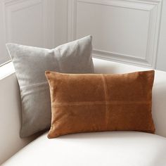 two pillows sitting on top of a white couch