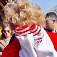 a woman with blonde hair wearing a red and white shirt