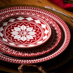 a red and white plate sitting on top of a wooden table