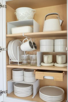 an open cabinet filled with dishes and pots