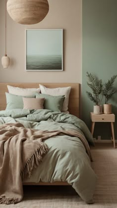 a bedroom with a large bed covered in green blankets and pillows, next to a painting on the wall