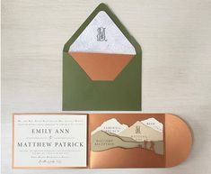 an envelope with a wedding card inside it and some paper on the front, along with a gold foil stamp