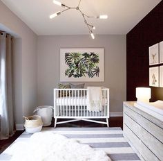 a baby's room with a white crib, dresser and art on the wall