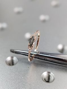 a diamond ring sitting on top of a pair of scissors next to some screws