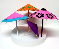 three different colored umbrellas are placed on top of each other in the shape of an umbrella