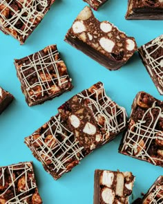 chocolate brownies with marshmallows are arranged on a blue surface