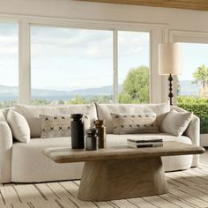 a living room filled with furniture and large windows overlooking the mountains in the back ground