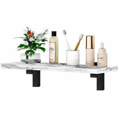 an assortment of beauty products sitting on a marble shelf with flowers in vases and toothbrushes