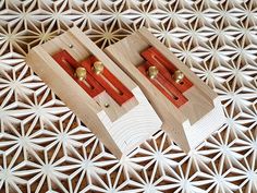 two pieces of wood sitting on top of a white and red table cloth covered floor