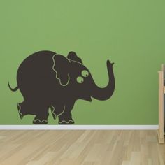 an elephant wall decal in a child's room with green walls and hardwood flooring