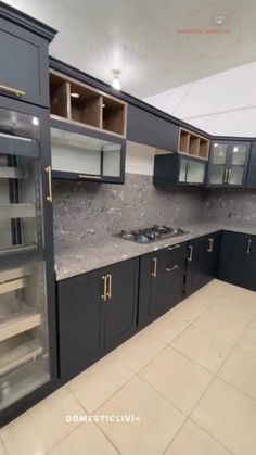 an empty kitchen with black cabinets and marble counter tops on the floor is pictured in this image