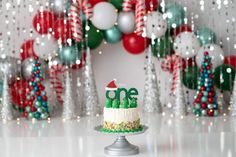 a cake sitting on top of a metal stand in front of balloons and streamers