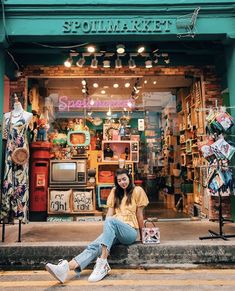 a woman sitting on the steps in front of a store