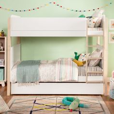 a child's bedroom with green walls and white bunk beds, rugs and toys on the floor