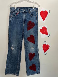 a pair of jeans with hearts painted on them next to cut out cards and clothes pins