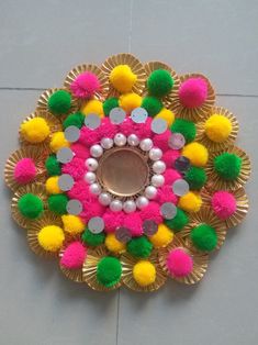 a decorative object with pom poms on the floor