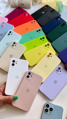 a person holding an iphone case in front of several colors of the same cell phone