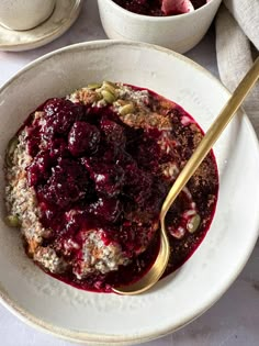 a bowl filled with oatmeal and fruit on top of a white table