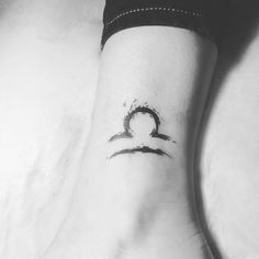 a woman's foot with a small tattoo on the side of her leg,