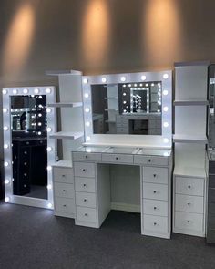 an assortment of vanity and makeup tables with lights on the wall behind them in a room