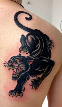 a black panther tattoo on the back of a woman's shoulder