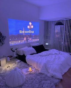 a bed room with a large screen on the wall