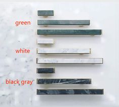 three different types of white and black gray marbles on a wall with the words green written below them