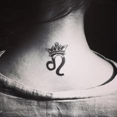 a black and white photo of a woman's neck with a crown on it