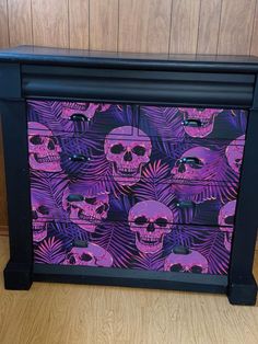 a purple and black dresser with skulls on it