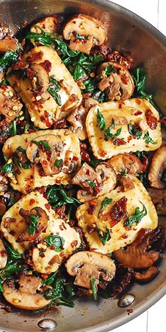 a pan filled with mushrooms and spinach on top of a wooden table