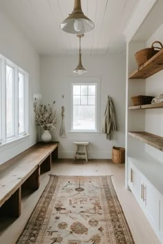 a large rug in the middle of a room with shelves on both sides and a window